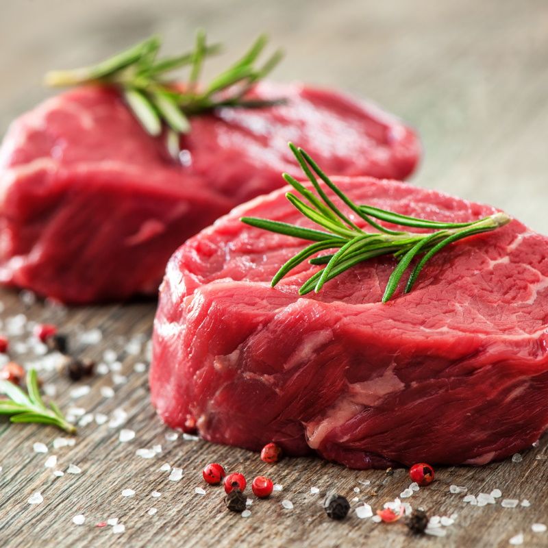 Raw Beef Fillet Steaks With Spices On Wooden Background