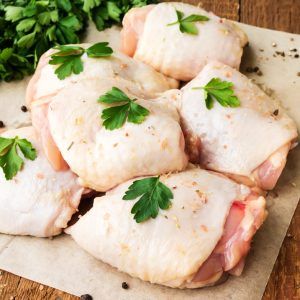 Raw Chicken Thighs With Parsley On Wooden Table