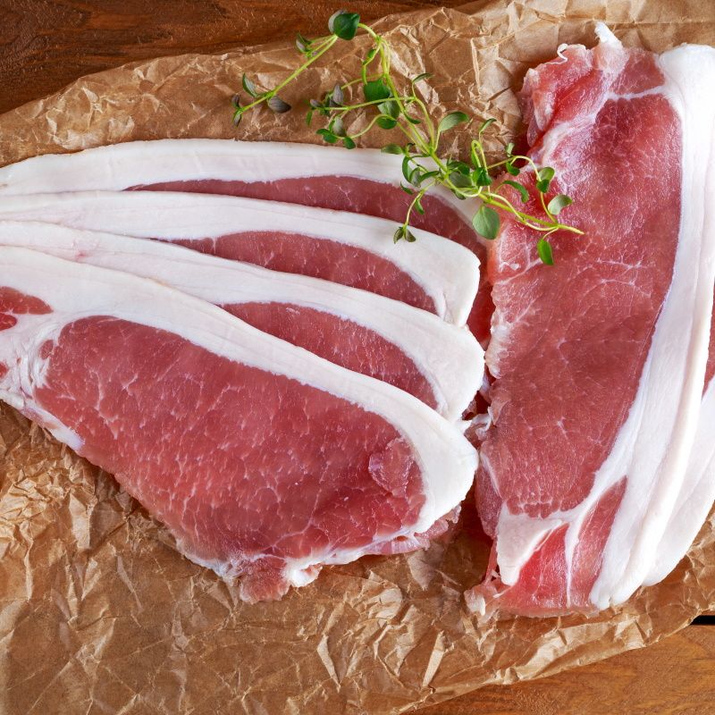 Raw Smoked Sliced Bacon On Crumpled Paper.