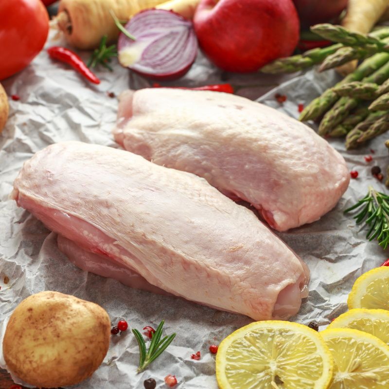 Raw Chicken Breast On Baking Paper With Variety Of Vegetables.