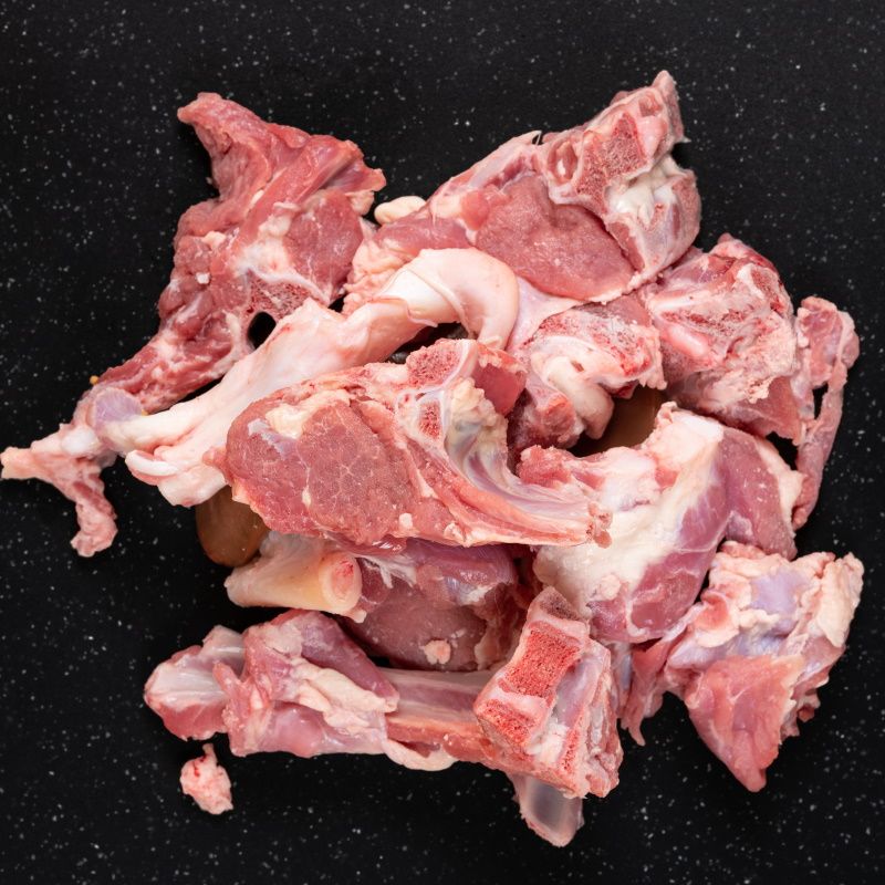 Fresh Raw Goat Meat Stew Like Cuts On Black Cutting Board.